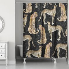 the shower curtain is decorated with leopards on black and gold glittered fabric, along with a round mirror