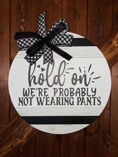 a sign that says hold on we're probably not wearing pants with a bow