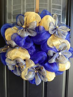 a blue and yellow wreath hanging on the front door