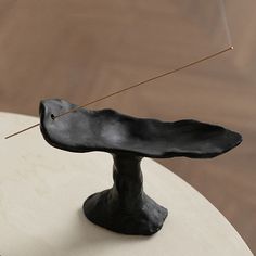 a black sculpture sitting on top of a white table