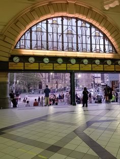 people are standing in the train station waiting for their trains