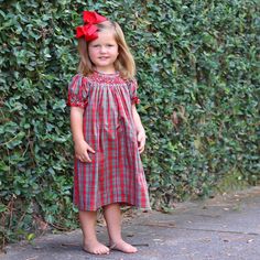 Create joyful memories with our Merry and Bright Plaid Smocked Dress. This green and red plaid dress is the perfect choice for your Christmas celebration. The dress features delightful geometric smocking and elegant bishop sleeves adorned with red ric-rac trim.