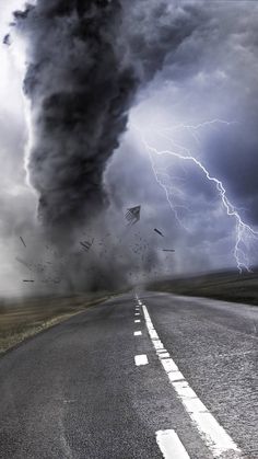 a black and white photo of a storm coming in from the sky over an asphalt road