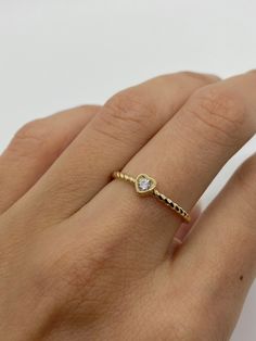 This beautiful heart 🤍ring 💍features a bezel set cubic zirconia stone with a twisted band detail on the sides. A simple, elegant ring great for wearing every day. * Solid 14K gold * AAAA quality CZ stone * Bezel set setting Visit us on Instagram @agoldmindjewelry for our custom jewelry designs and newest listings ▬ All jewelry pieces are sent in a gift box ▬ Our shipping and return policies: ~ Items will be shipped Free via USPS First Class Mail. We gladly accept returns, exchanges, and cancel Stackable Heart Ring For Everyday And Valentine's Day, Everyday Stackable Heart Ring For Valentine's Day, Valentine's Day Dainty Heart Ring With Diamond Accents, Valentine's Day Heart Ring With Single Diamond, Heart Ring With Bezel Setting For Promise, Valentine's Day Heart-shaped Rings With Bezel Setting, Beaded Heart Ring, Band Valentines, Ring Twisted Band