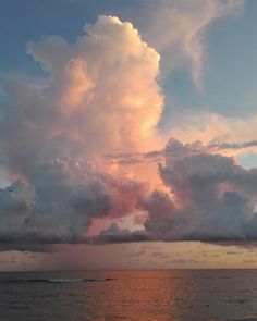 the sky is filled with pink clouds over the ocean at sunset or sunrise hours ago