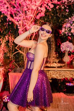 a woman in a purple dress posing for the camera