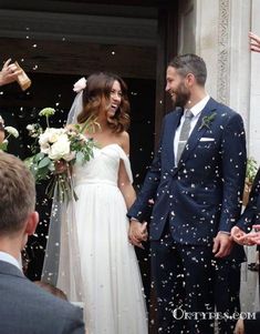 a newly married couple standing in front of confetti thrown from the air at them