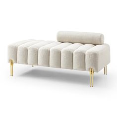 a white couch with gold legs on a white background