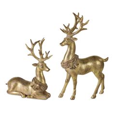 two brass deer figurines sitting next to each other on a white background,