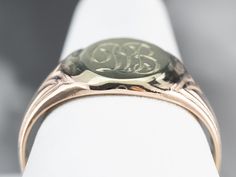 "Featuring components from different eras, this one-of-a-kind signet ring is a delightful combination of green and rose gold! The monogram at the center is beautifully engraved in ornate French script, while the ring's shoulders have subtle motifs that catch the light and shine. Please note that this signet ring has an original monogram, and unfortunately, this piece cannot be altered without affecting the quality of the piece. Please feel free to contact us to help you find your perfect signet Anniversary Domed Hallmarked Signet Ring, Anniversary Hallmarked Domed Signet Ring, Collectible Yellow Gold Signet Ring With Initials, Luxury Anniversary Signet Ring With Maker's Mark, Luxury Yellow Gold Signet Ring With Maker's Mark, Antique Signet Ring For Formal Occasions, Heirloom 14k Gold Signet Ring With Maker's Mark, Heirloom 14k Gold Jewelry With Maker's Mark, Polished Round Signet Ring Collectible