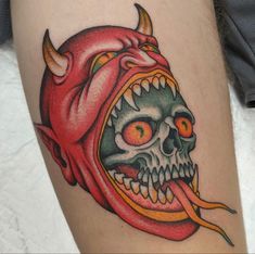 a close up of a person's leg with a tattoo on it and a demon head