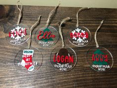 six personalized christmas ornament hanging from twine string on wooden table top