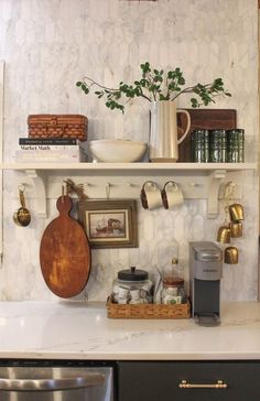 a kitchen counter with pots, pans and other items on the shelves above it