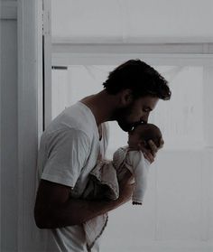 a man holding a baby in his arms