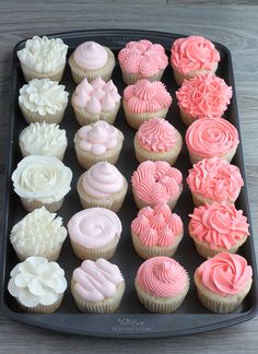 a tray filled with cupcakes on top of a wooden table