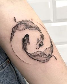 a woman's arm with two koi fish on it