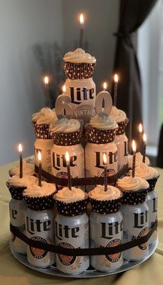 a birthday cake made out of beer cans with lit candles on top and chocolate cupcakes in the middle