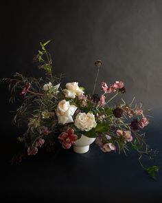 a white vase filled with lots of flowers