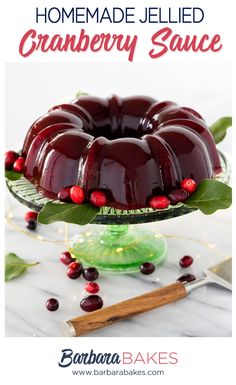 a bundt cake with cranberry sauce and leaves on top, sitting on a glass platter