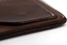 two brown leather wallets sitting on top of each other next to eachother