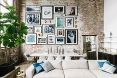 a living room filled with white furniture and pictures on the wall above it's coffee table