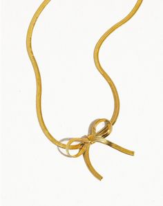 Adorn yourself with the opulent Golden coquette choker, a radiant companion to our bow earrings of matching allure.💛 The 18k Golden Coquette Flat Bow Snake Chain Choker features a sleek and smooth chain that lies flat against the skin, offering a modern and chic look. The centerpiece is a meticulously crafted bow, adding a feminine and delicate touch to the overall design. The combination of the flat chain and the bow creates a harmonious balance between minimalism and elegance. 🎀Key Features? Formal Gold Jewelry With Bow, Formal Gold Necklaces With Ribbon, Elegant Gold Jewelry With Ribbon, Formal Gold Necklace With Ribbon, Gold Ribbon Jewelry For Formal Occasions, Yellow Gold Jewelry With Decorative Bow For Party, Party Jewelry In Yellow Gold With Bow Detail, Gold Jewelry With Decorative Bow For Wedding, Elegant Yellow Gold Jewelry With Ribbon