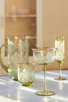 three glasses sitting on top of a table next to each other with gold rims