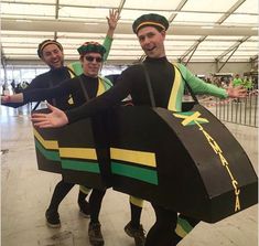 three men dressed in green and yellow costumes are posing for the camera with their hands up