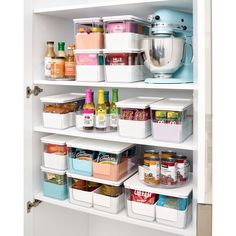 an organized pantry with containers, food and condiments on the shelves in white