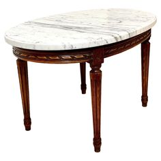 an oval marble top table with wooden legs