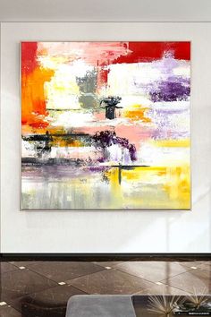 an abstract painting hangs on the wall above a coffee table