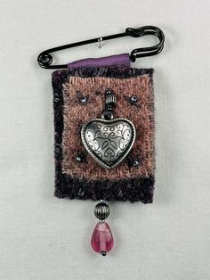 a piece of cloth with a heart hanging from it's side on a hook