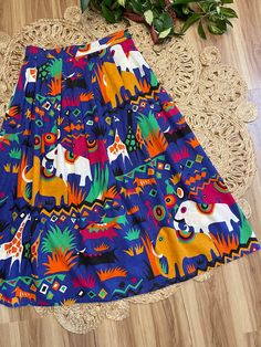 "Love this one so bright and cheerful. 80's Safari print midi skirt by Batya. Buttons on the side. Pockets at the hips. Bold colorful elephants, giraffes and antelope print. Purple, gold, black, green, and orange. Such a fun piece. In good vintage condition. Measurements taken while item was laying flat. Waist: 15\" Length: 35.5\"" Fun Multicolor Skirt For Summer, Casual Multicolor Skirt With Vibrant Print, Fun Multicolor Summer Skirt, Playful Multicolor Skirt With Elastic Waistband, Multicolor Retro Skirt For Vacation, Retro Multicolor Skirt For Vacation, Antelope Print, Colorful Giraffe, Ginger Dress