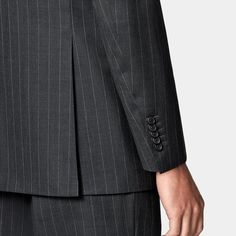 This dark grey striped suit is cut to a tailored fit, featuring a slim chest and waist, padded shoulder, and wide notch lapel. Paired with wide-leg tapered trousers, it has a high-rise, single pleat, and belt loops. Pinstripe Double Breasted Suit With Notch Lapel For Work, Striped Tuxedo Suit For Business, Notch Lapel Suits With Vertical Stripes For Business Casual, Pinstripe Tuxedo Suit For Work, Pinstripe Suit With Welt Pockets And Suit Collar, Classic Suits With Vertical Stripes And Notch Lapel, Striped Suit With Notch Lapel, Striped Notch Lapel Suit In Suiting Fabric, Striped Notch Lapel Suit