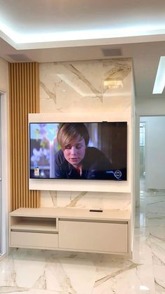 a flat screen tv mounted to the side of a wall in a room with marble flooring