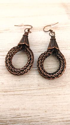 pair of earrings on wooden table with white background