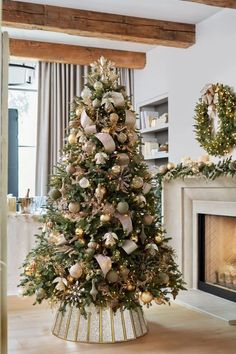 a christmas tree in a living room decorated with gold and silver ornaments, surrounded by wreaths