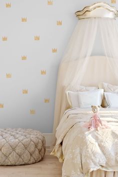 a bed with a white canopy over it next to a small round footstool