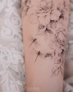 a woman's leg with flowers and dragonflies on it