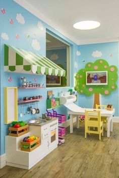 a child's playroom with blue walls and wooden floors