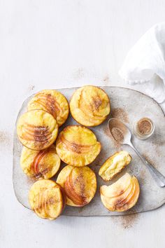 sliced peaches on a plate with a spoon and napkin next to them, ready to be eaten