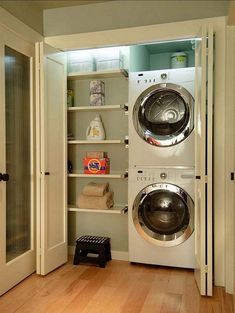 a washer and dryer in a room with wood flooring next to an open door