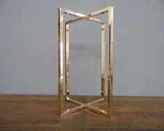 a square mirror sitting on top of a wooden floor