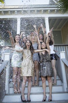 a group of young women standing on top of a set of stairs covered in confetti