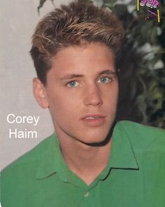 a young man in a green shirt looking at the camera