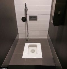 a white toilet sitting inside of a bathroom stall