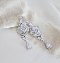 "Beautiful long statement earrings feature an Art Deco style with delicate details. Created with luxurious Swarovski Pure Brilliance stones set in a metal setting and embellished with a lovely crystal halo. Finished with Swarovski pearls. You can also choose a cz teardrop instead of pearls. Earrings measure 3\" x 1\" Available in 3 finishes Matching pieces: https://www.etsy.com/listing/475999054/rose-gold-bridal-bracelet-crystal https://www.etsy.com/listing/489501555/rose-gold-necklace-bridal-ne Glamorous Drop Chandelier Earrings With Elegant Design, Glamorous Crystal Chandelier Earrings With Elegant Design, Glamorous Dangle Chandelier Earrings With Elegant Design, Opulent Silver Earrings For Wedding, Elegant Crystal Chandelier Earrings, Elegant Long Drop Chandelier Earrings With Sparkling Stones, Exquisite Dangle Chandelier Earrings, Ornate Wedding Diamond Drop Earrings, Luxury Dangle Linear Earrings For Wedding