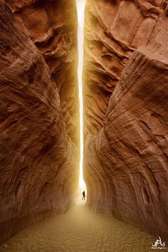 a person standing in the middle of a canyon with an open door leading into it