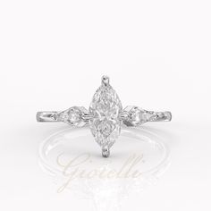 a pear shaped diamond engagement ring on a white background