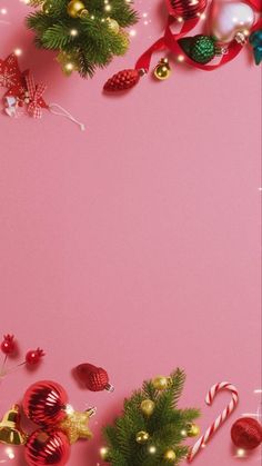 christmas decorations and candy canes on a pink background